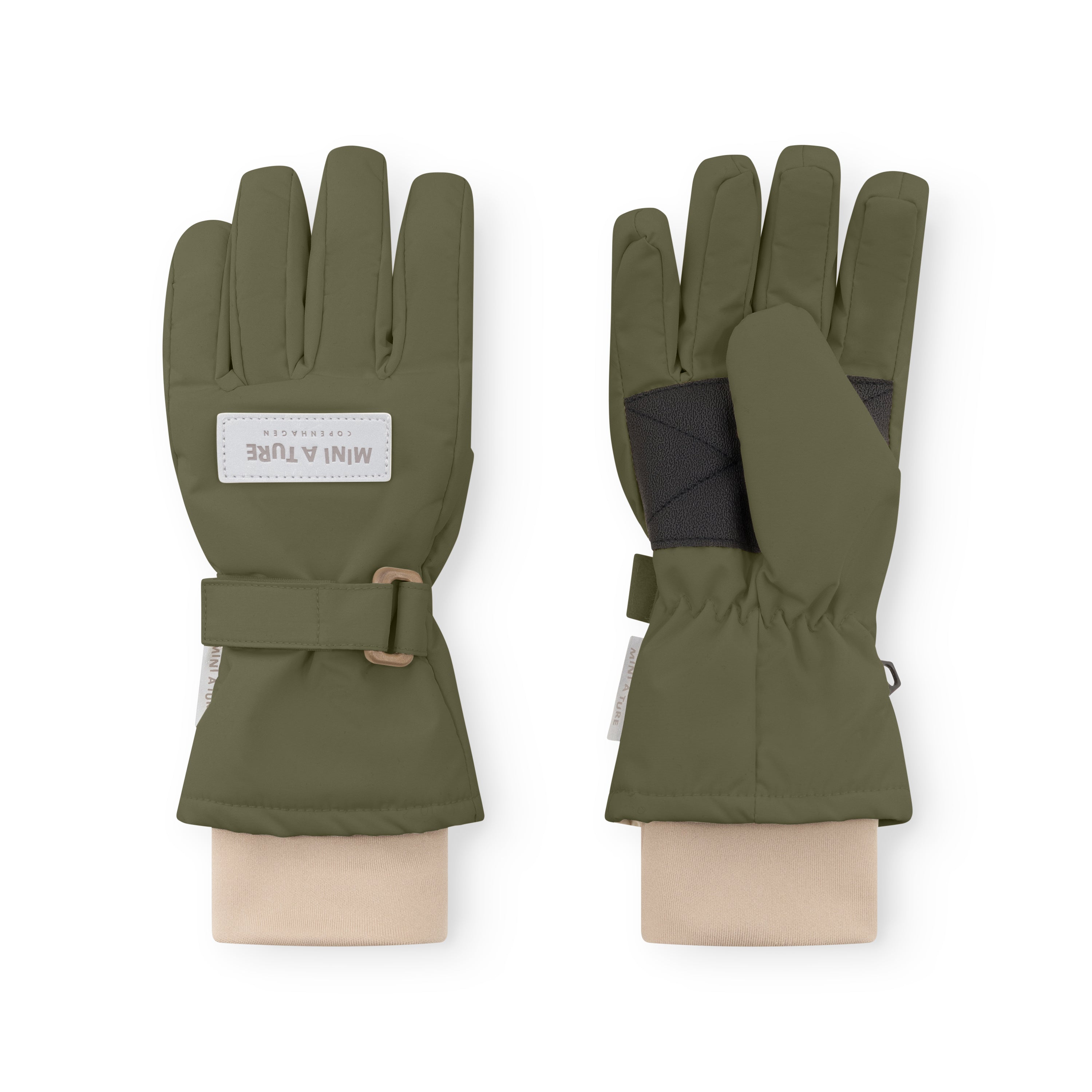 MATCELIO gloves in olive green displayed on neutral fabric wrists, showing both palm and back views with the white embossed MINI A TURE Copenhagen label on the back of hand, black elasticated internal wrist cuff visible beneath the extended cuff, and the adjustable buckle strap fastened on the outer cuff.