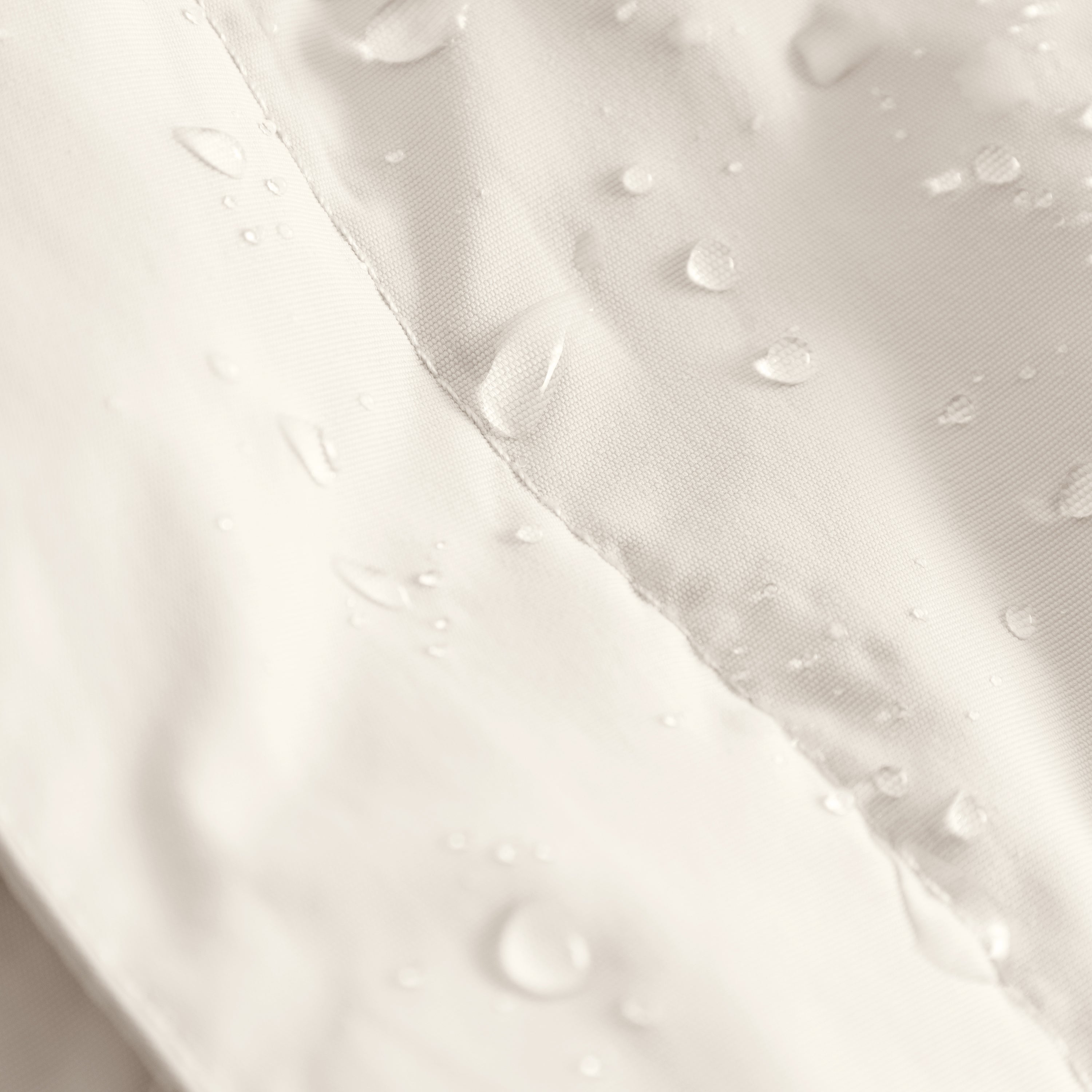 Close-up of the MATWANG fleece-lined winter jacket's waterproof recycled nylon shell in soft cream with water droplets beading across the surface, demonstrating the fluorine-free Bionic Finish Eco treatment, with flat-felled seam construction and soft beige fleece lining visible at the edge.