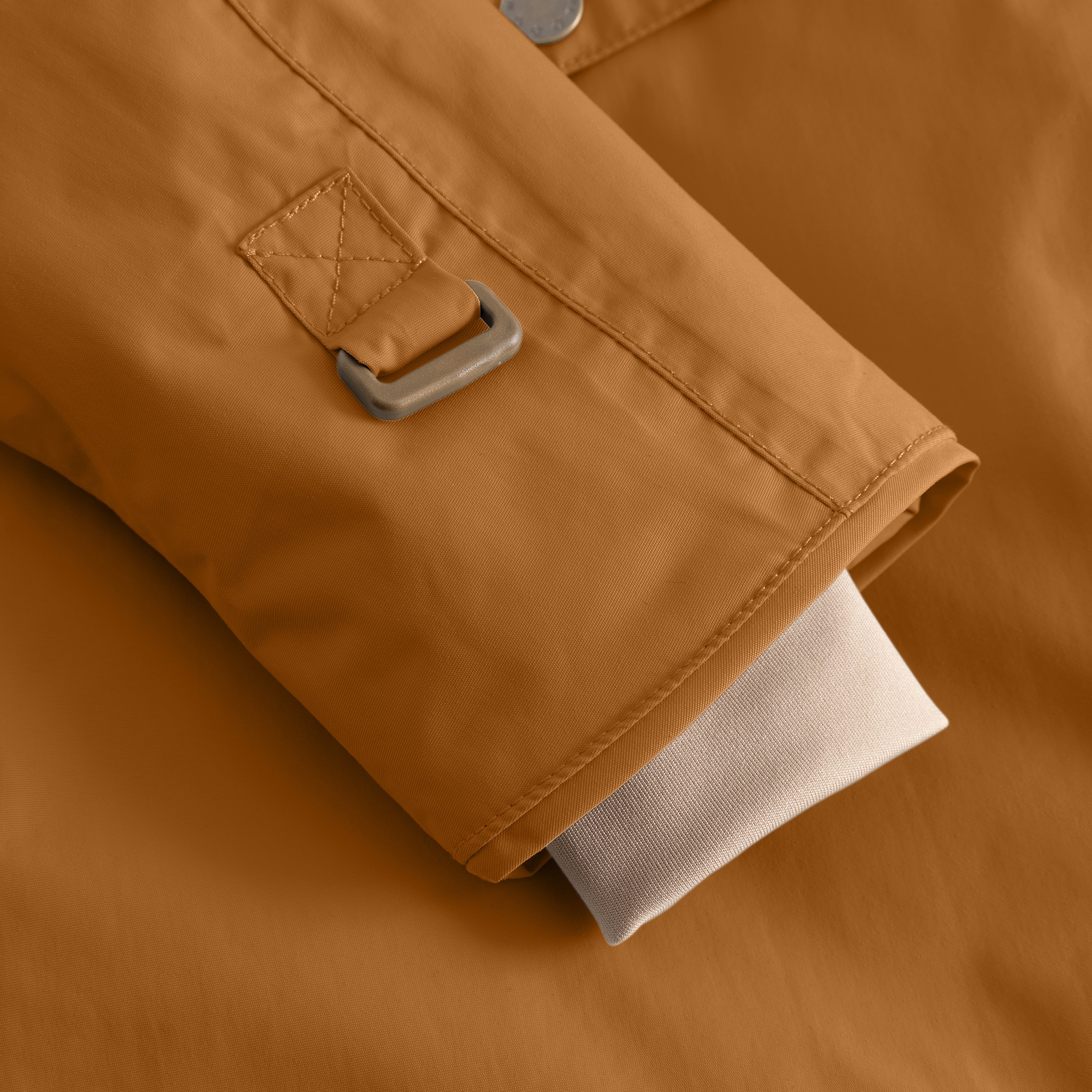 Detail of the MATWANG fleece-lined winter jacket's adjustable internal waist tab in warm brown with a grey plastic buckle and flat-felled stitching, showing the elastic adjustment mechanism at the side seam.