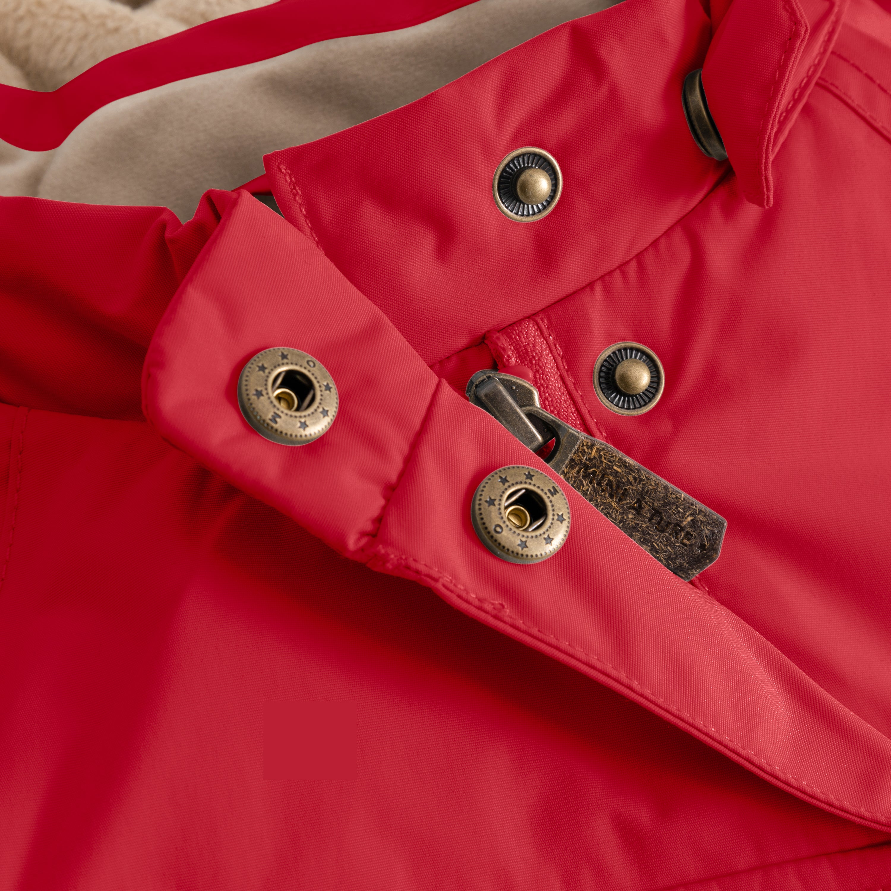 Close-up of the MATWANG fleece-lined winter jacket's detachable pointed hood showing the press-stud fastening system with bronze-toned metal snaps and a red fabric loop, demonstrating the hood's removable design and secure attachment mechanism.