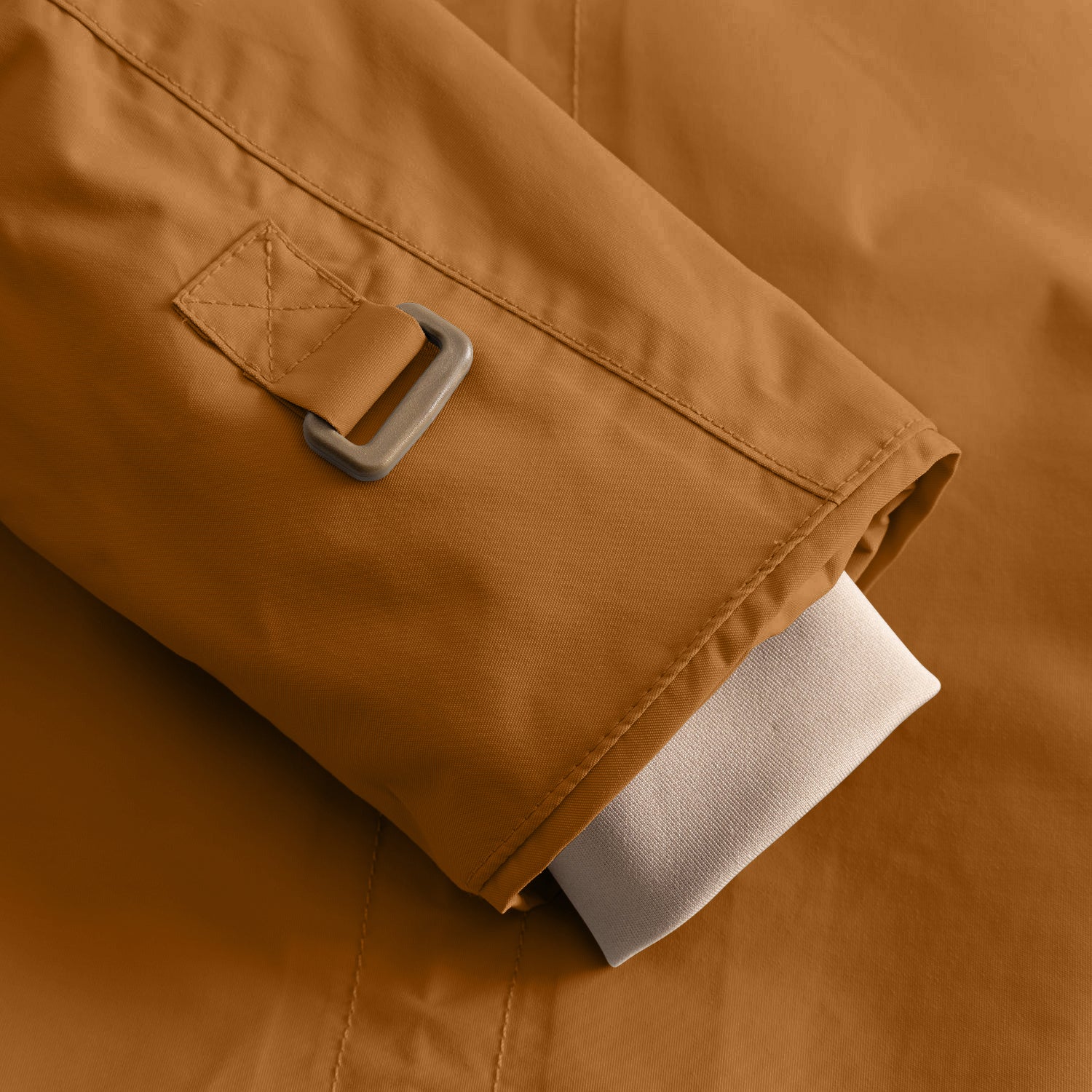 Detail of the MATWALLY fleece lined winter jacket sleeve in caramel brown, showing the metal D-ring with fabric tab for snow cuff adjustment and the beige ribbed inner cuff with thumb opening visible at the hem.