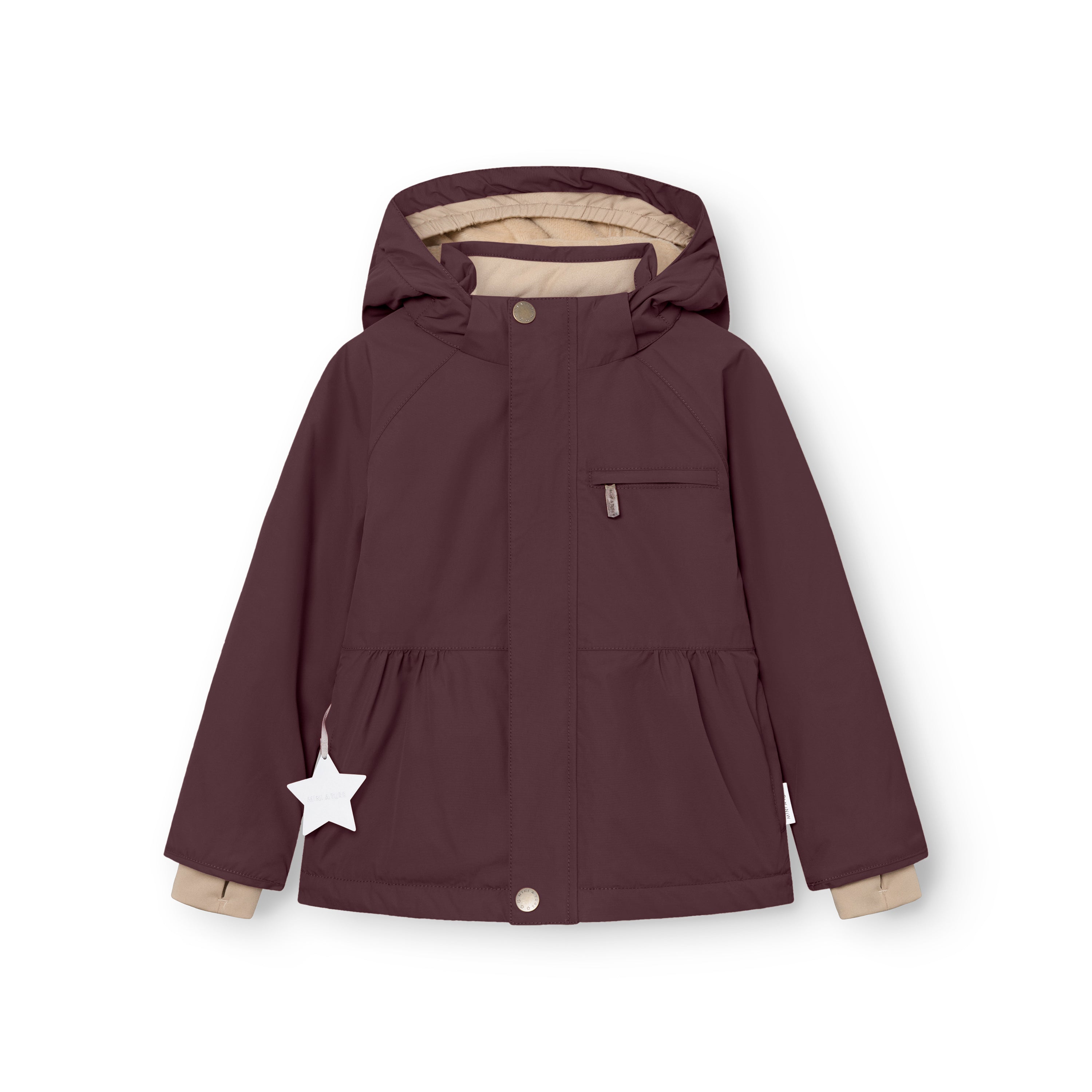 Young girl wearing the MATBRIDDINE winter jacket in dusty pink with hood up, smiling outdoors, showing the gathered waist detail, beige inner lining at the cuffs and the white reflective star on the right pocket.