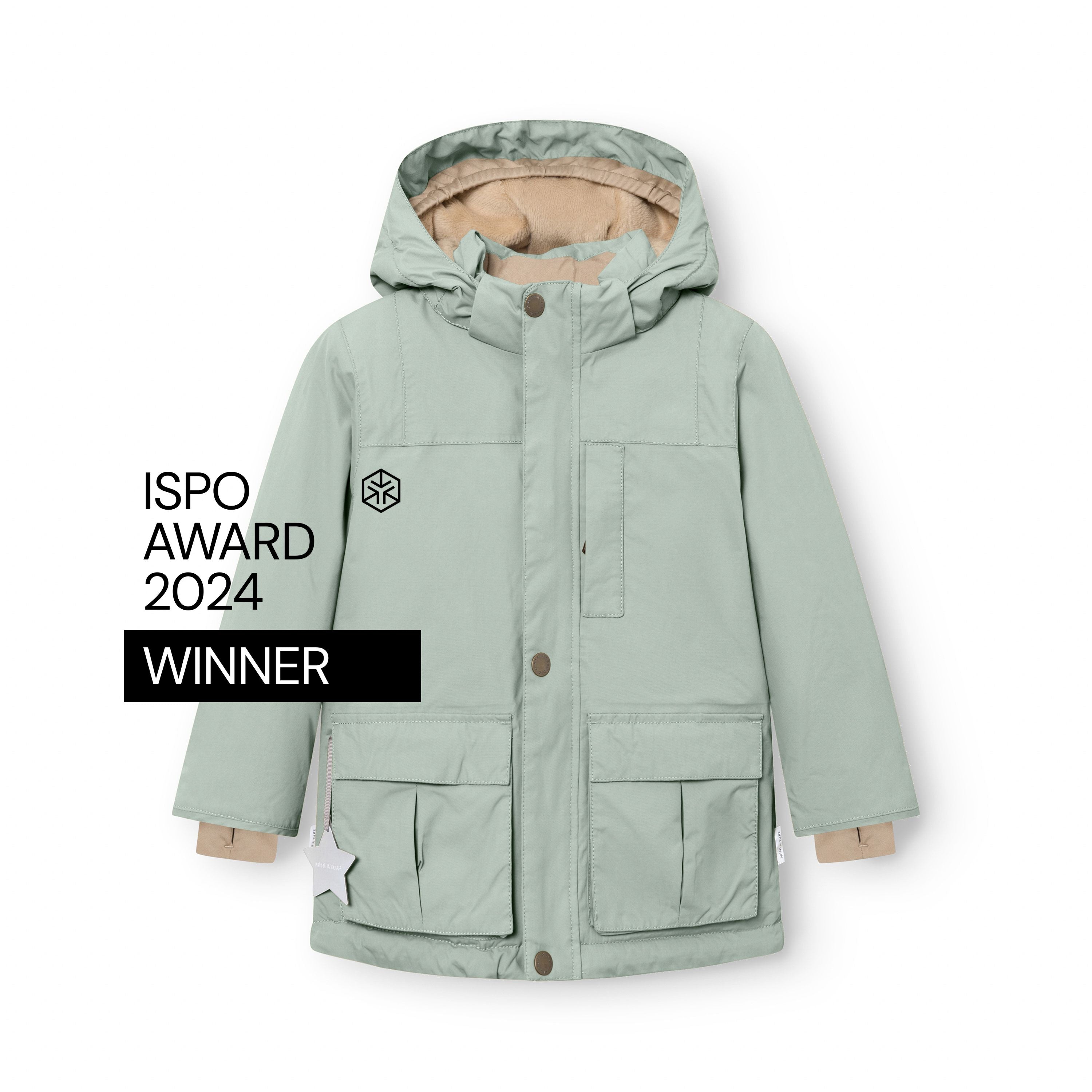 Sage green MATKASTORIO fleece lined winter jacket displayed flat with hood attached, showing front snap-button closure, large cargo-style flap pockets, beige fleece lining visible at the cuffs and hood, white reflective star detail on the right pocket, and ISPO Award 2024 Winner badge on the left chest.