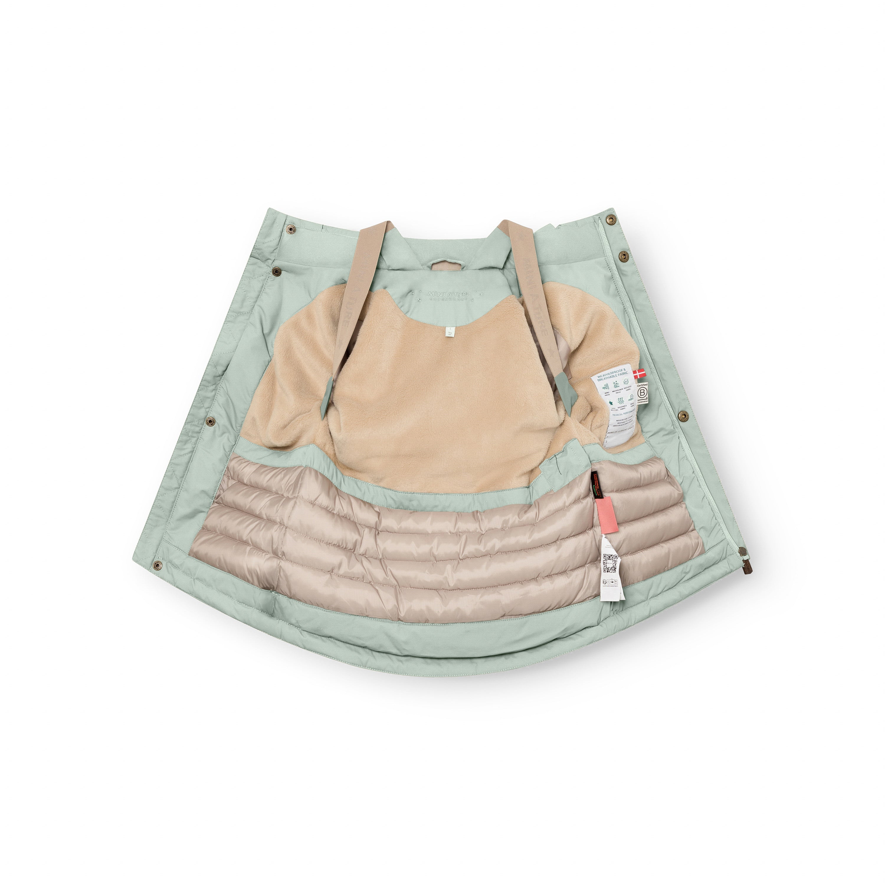 Sage green MATKASTORIO fleece lined winter jacket opened fully to show the internal construction, with beige fleece lining across the upper body, beige adjustable suspenders, cream Sorona Aura padded lower section with horizontal quilting, and product care labels visible on the inner right side.