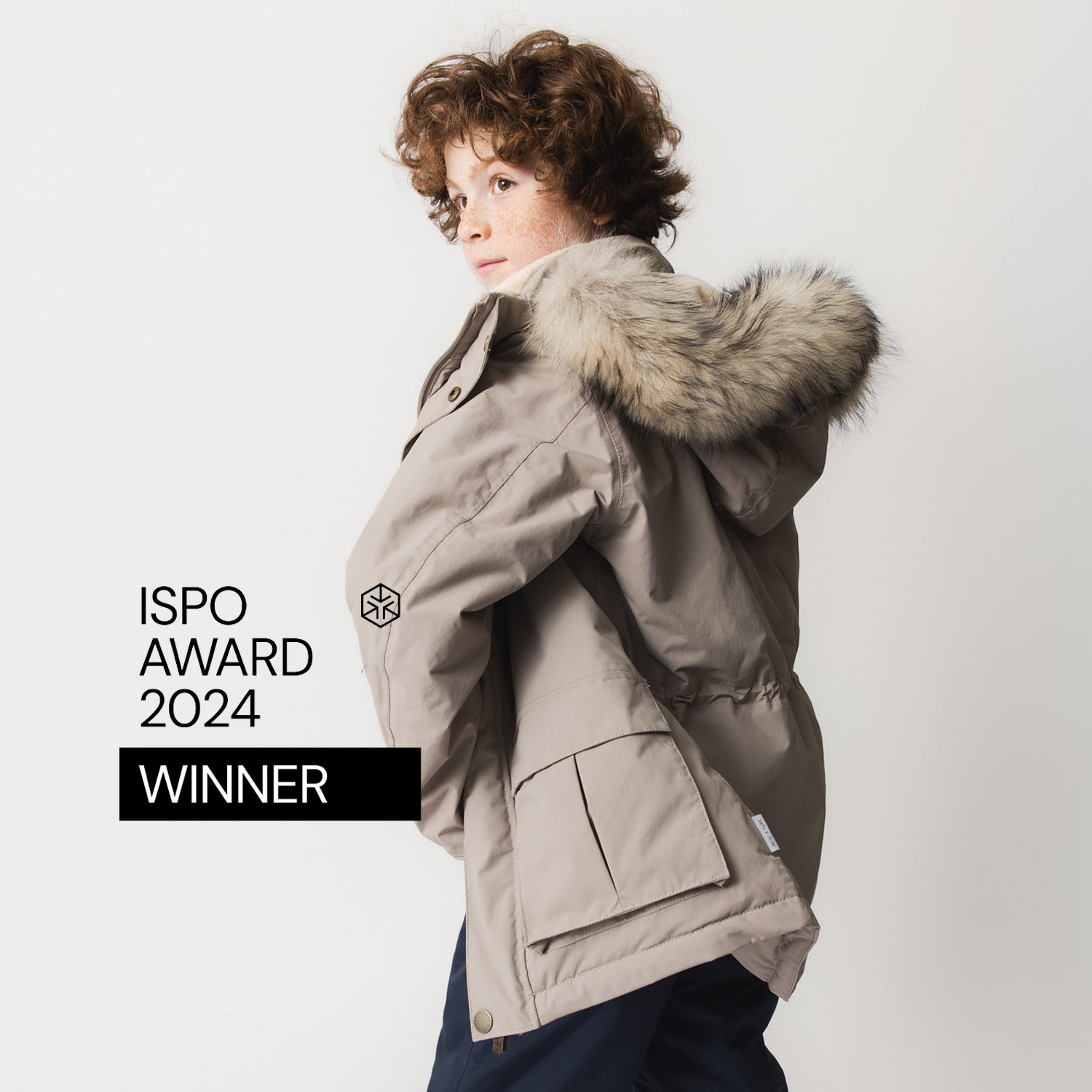 MATKASTORIO fleece lined winter jacket in beige with detachable genuine fur trim on the hood, worn by a child shown from behind, featuring a waterproof shell, rear pockets and reflective details.