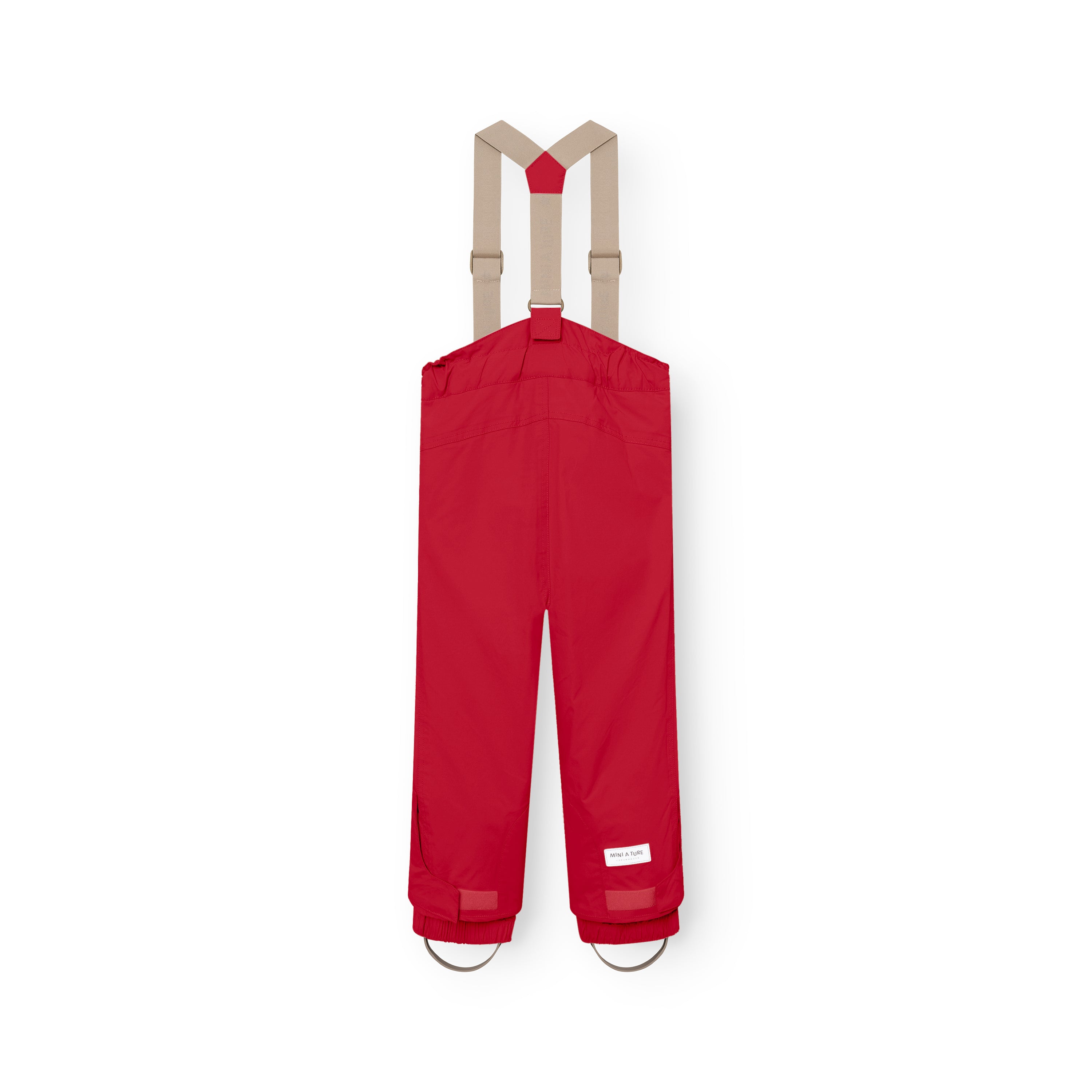 MATWITTE snow pants in bright red viewed from the back, showing the cross-back elastic suspender attachment, elasticated ankle cuffs with integrated foot straps, and the MINI A TURE label positioned at the lower leg.