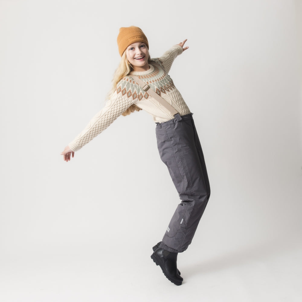 MATWITTE snow pants in charcoal grey viewed from the back, showing the cross-back elastic suspender attachment, elasticated ankle cuffs with integrated foot straps, and the reinforced lower leg construction designed to withstand contact with snow and ski equipment.