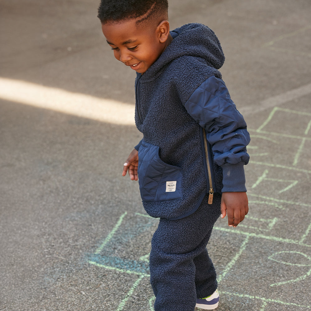 Boy outside playing and is wearing a blue teddyfleece pants and jacket