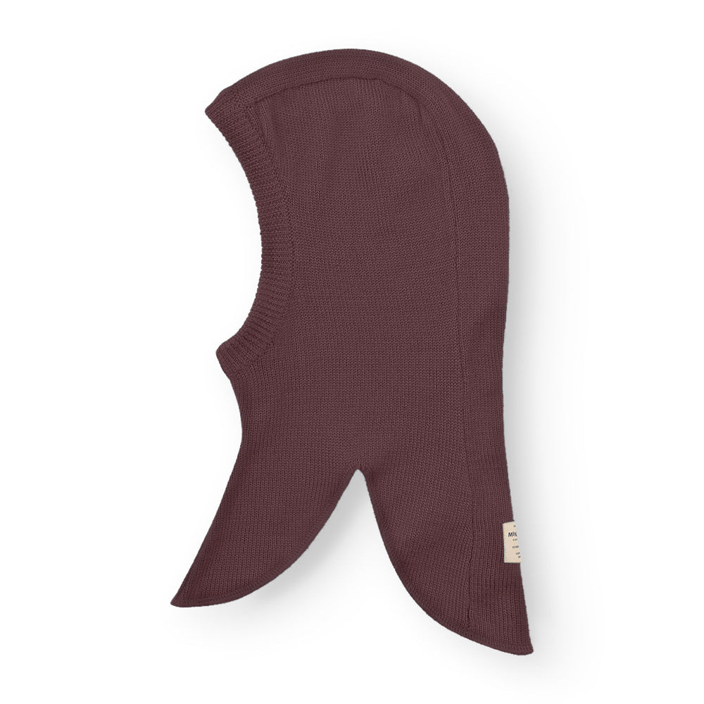 MATKEA light balaclava in deep plum merino wool, laid flat to display the distinctive extended neck panels and face opening that provide comprehensive coverage for cold-weather layering.