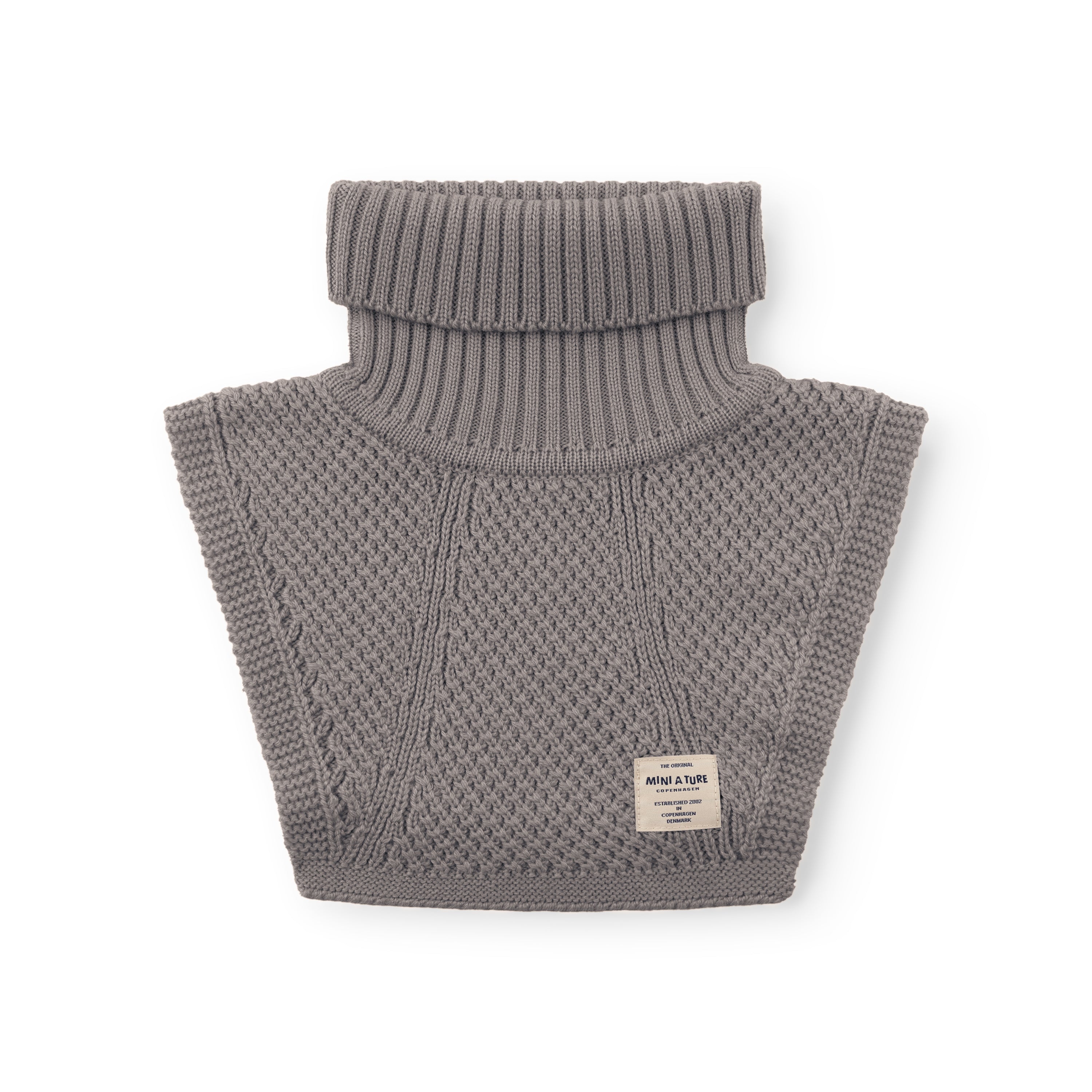 MATTAYLER neckwarmer in grey merino wool, photographed flat against a white background, showing the wide ribbed high neck and moss-stitch textured body with a cream MINI A TURE label positioned at the lower right of the front panel.