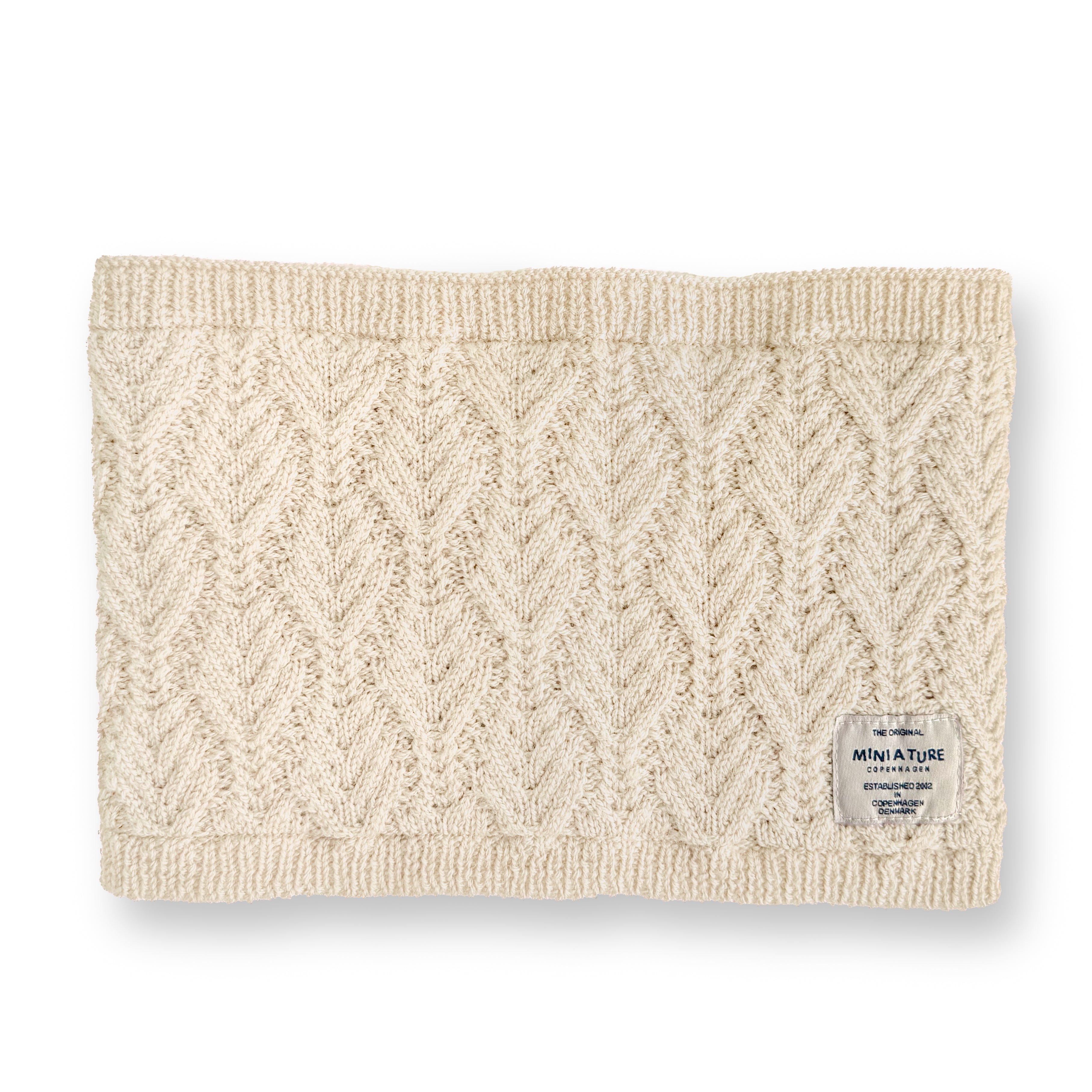 MATGOI fleece lined neckwarmer displayed flat in natural cream merino wool with a chevron knit pattern, ribbed top and bottom edges, and a woven MINI A TURE label at the lower right.