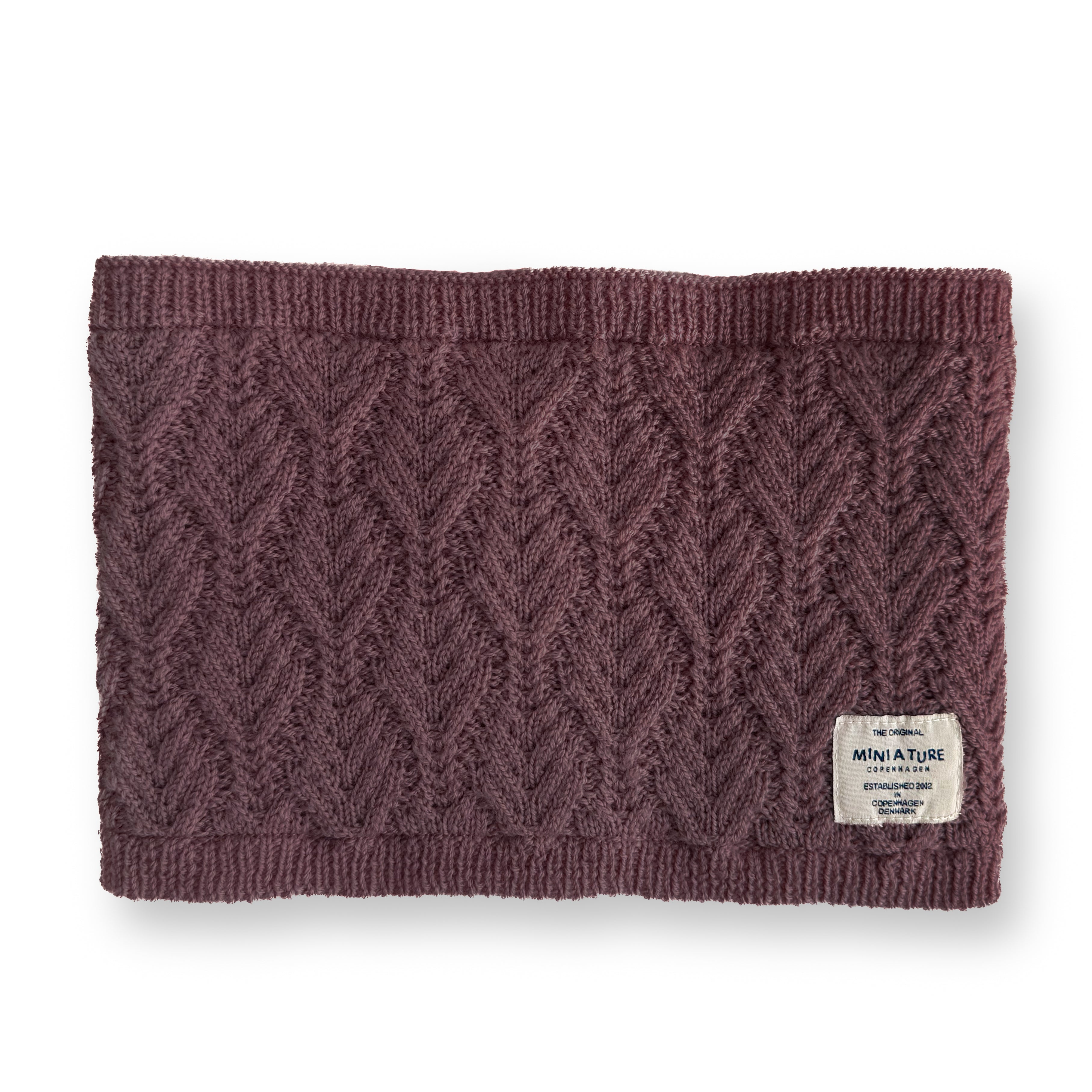 MATGOI fleece lined neckwarmer displayed flat showing the rich plum-toned merino wool outer with chevron knit texture, ribbed edges and MINI A TURE woven label at the lower right.