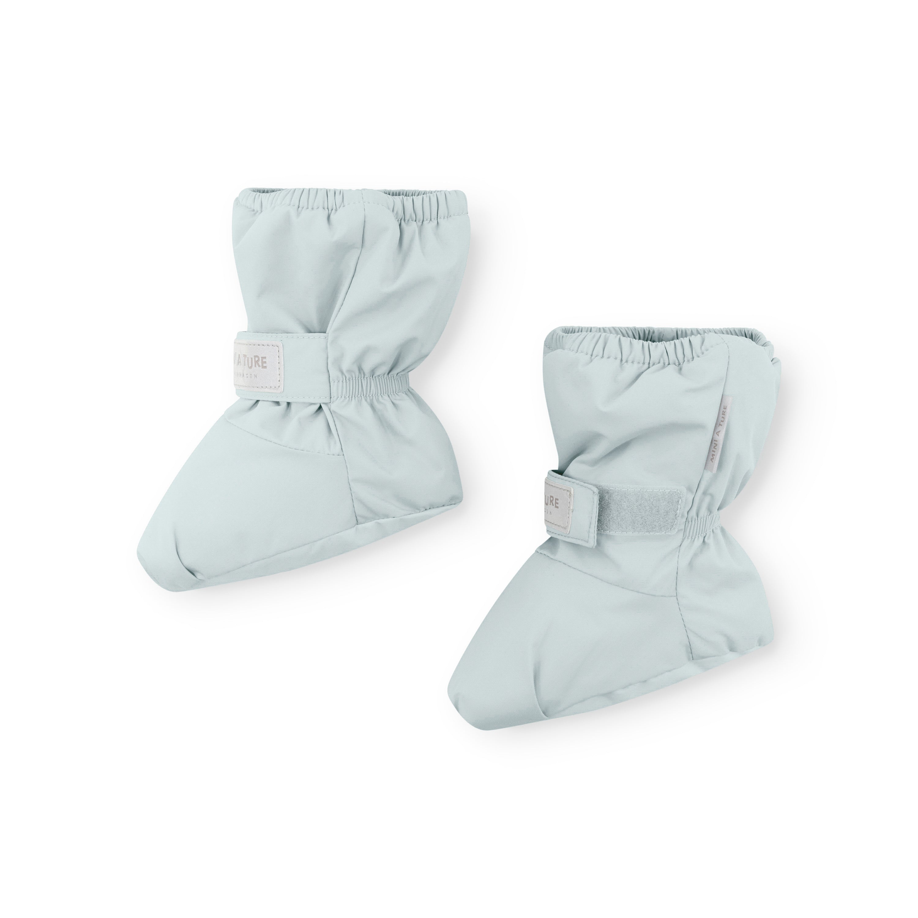 MATWINN waterproof baby outdoor socks in soft mint blue with elasticated ankle and velcro strap closure, photographed as a pair to show the padded foot construction and recycled polyamide outer designed for pram journeys in cold weather.