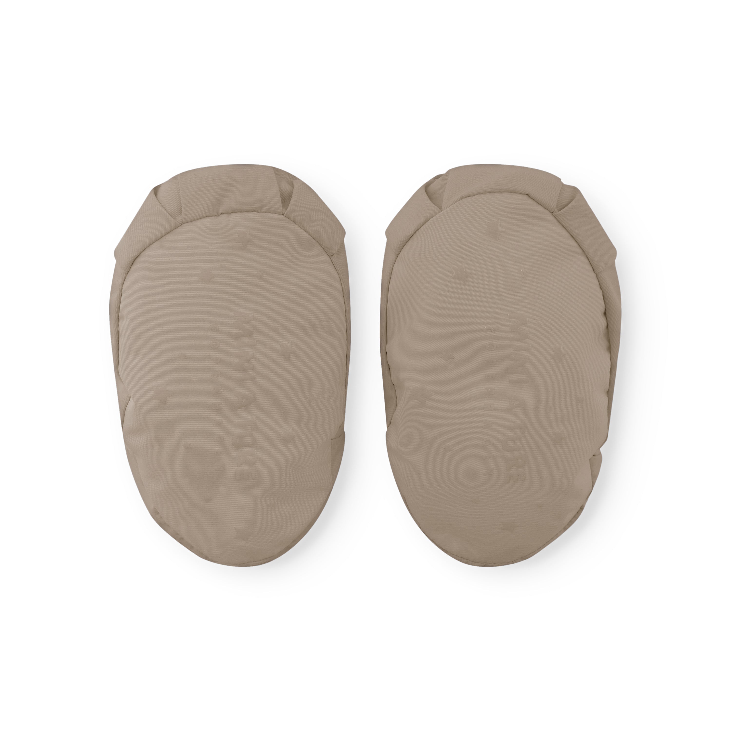Pair of MATWINN insulated baby outdoor socks in warm beige with fleece lining and windproof recycled nylon shell, displayed flat to show the rounded toe shape and padded construction for non-walking infants.