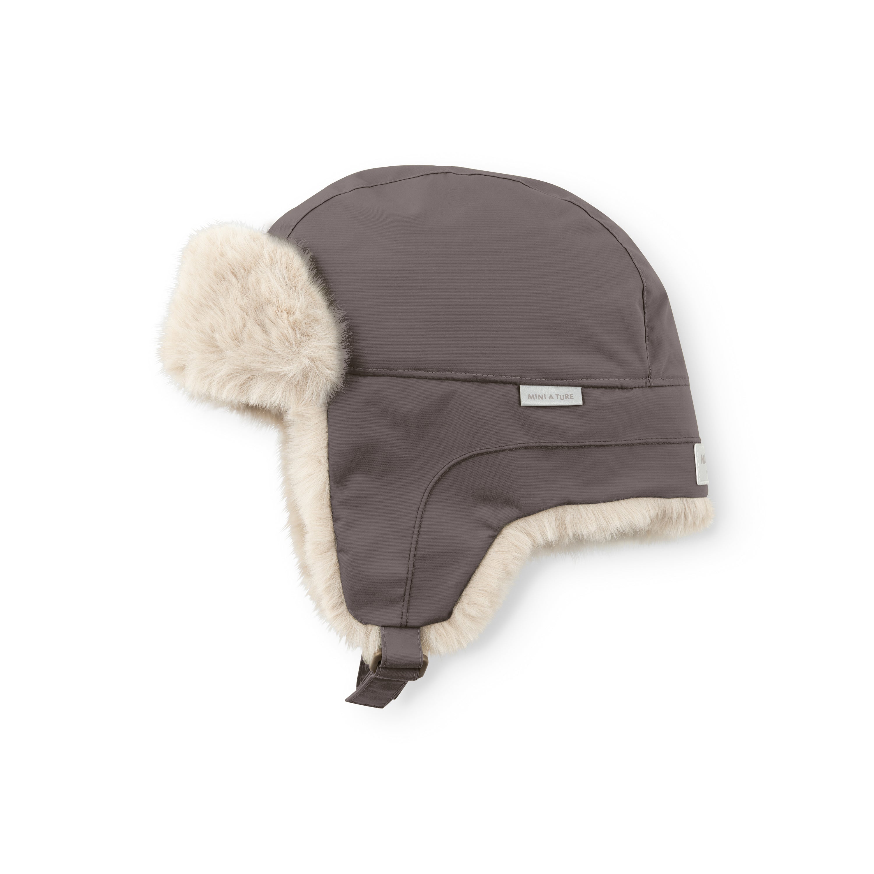 MATCRISTER waterproof trapper hat in dark grey with thick cream fleece lining and ear flaps, photographed flat against a white background showing the taped seams, velcro chin strap and MINI A TURE woven label on the side.