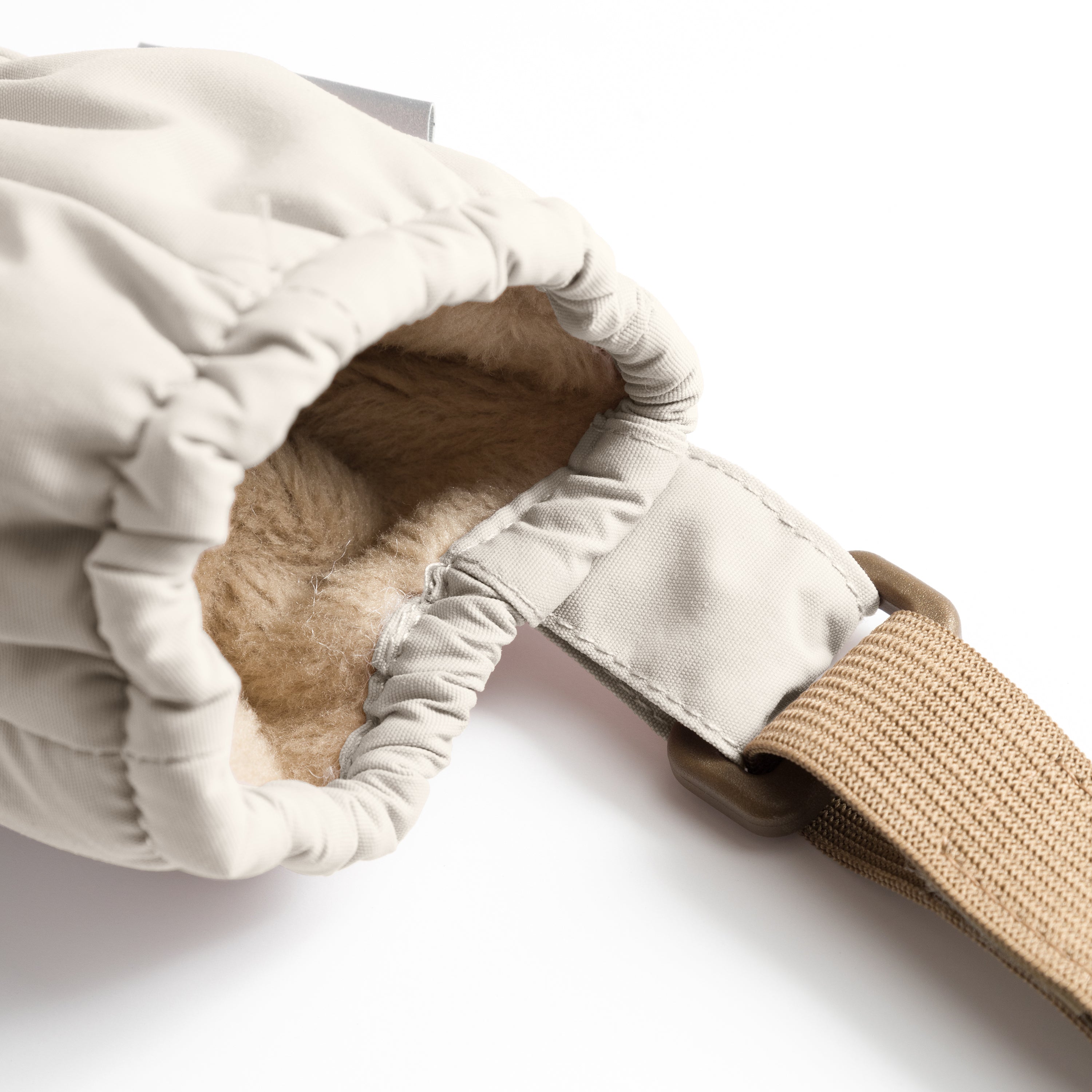 MATCORDT fleece lined mittens in pale cream shown turned inside out, revealing the soft beige fleece lining and THINSULATE padding at the interior, with the elastic gathered cuff visible at the wrist opening and the extended beige velcro attachment strap alongside the waterproof recycled polyamide outer shell.