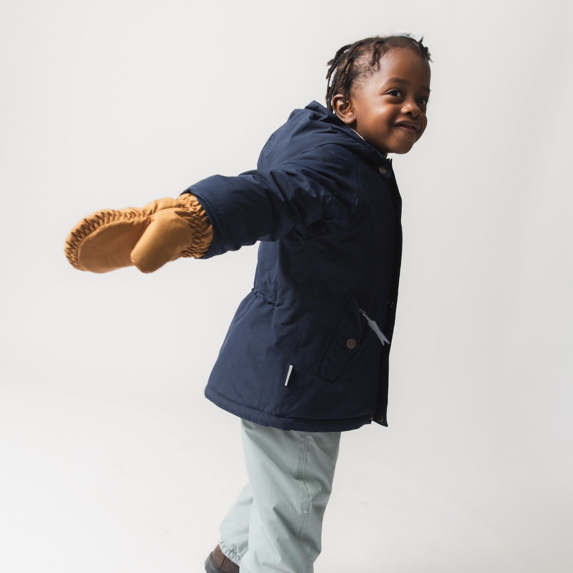 MATCORDT fleece lined mittens in caramel brown worn by a young child during active movement, demonstrating the freedom of grip and flexibility the THINSULATE padded construction provides without bulk or stiffness during outdoor play.
