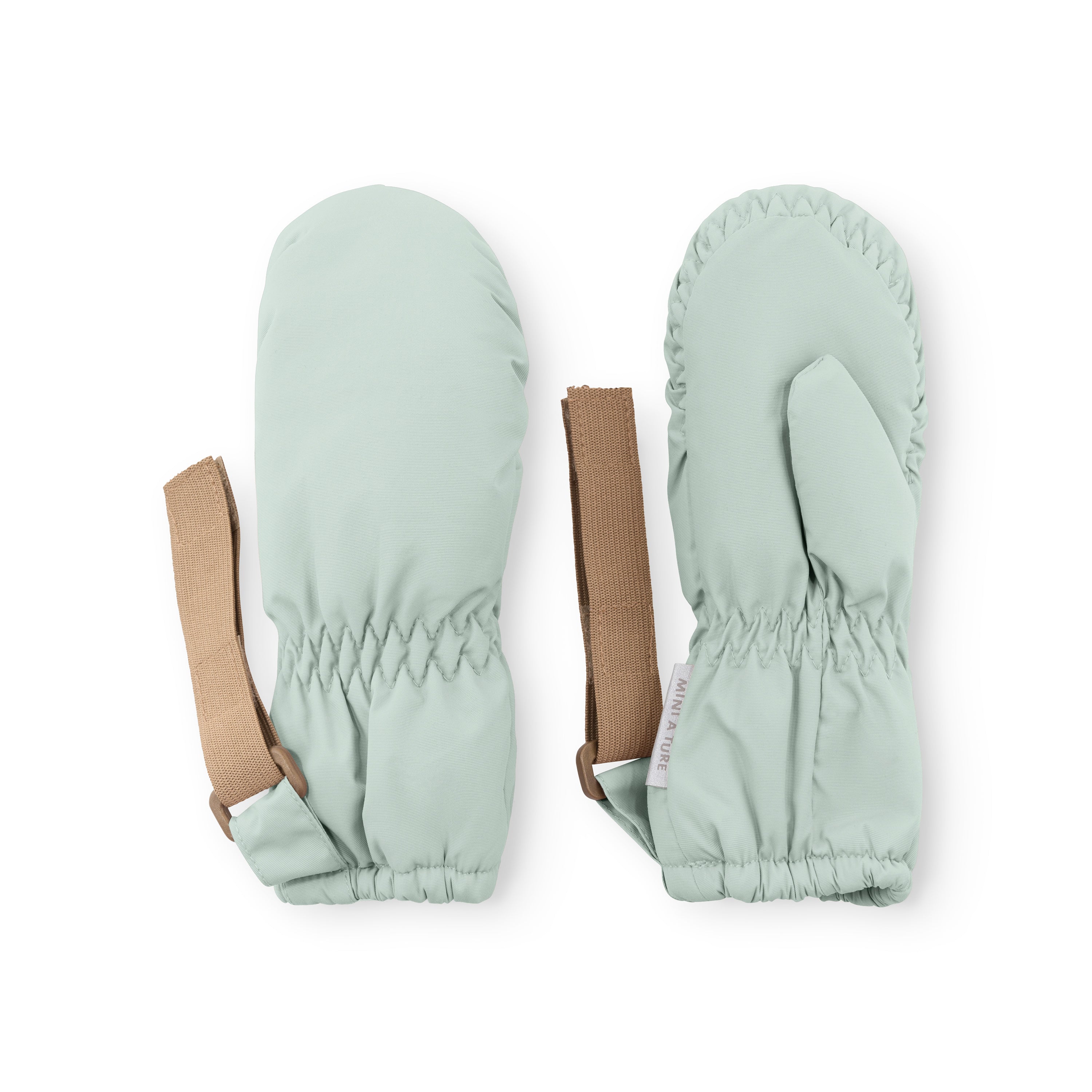 MATCORDT fleece lined mittens in pale mint green displayed flat on a white background, showing both palm and back views with elastic gathered cuffs, extended beige velcro attachment straps and the waterproof recycled polyamide outer shell.