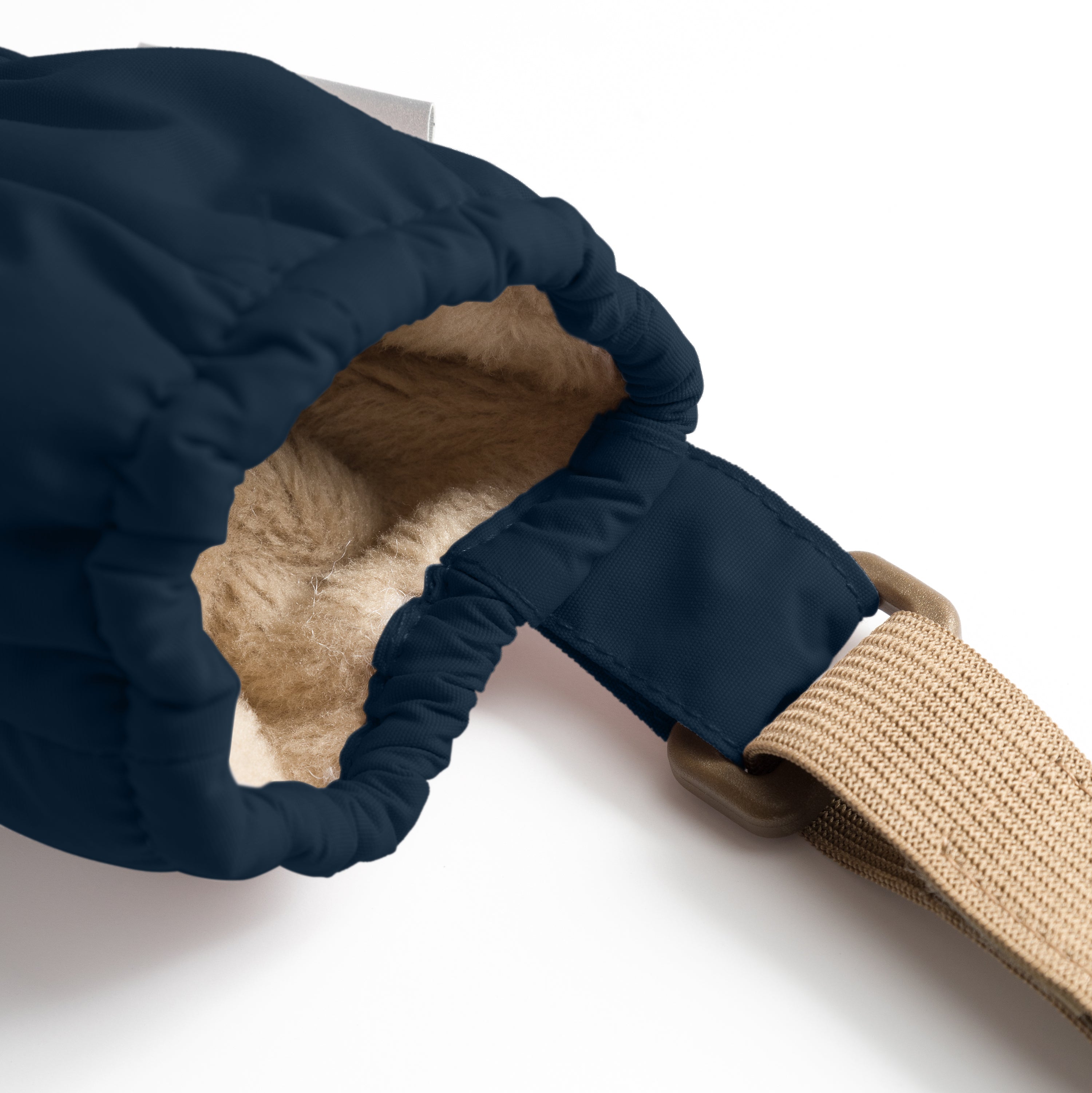 MATCORDT fleece lined mittens in navy blue worn on a hand, showing the elastic gathered wrist sealing snugly against the skin, the waterproof recycled polyamide shell and the beige velcro attachment strap extending from the cuff alongside a matching jacket sleeve.