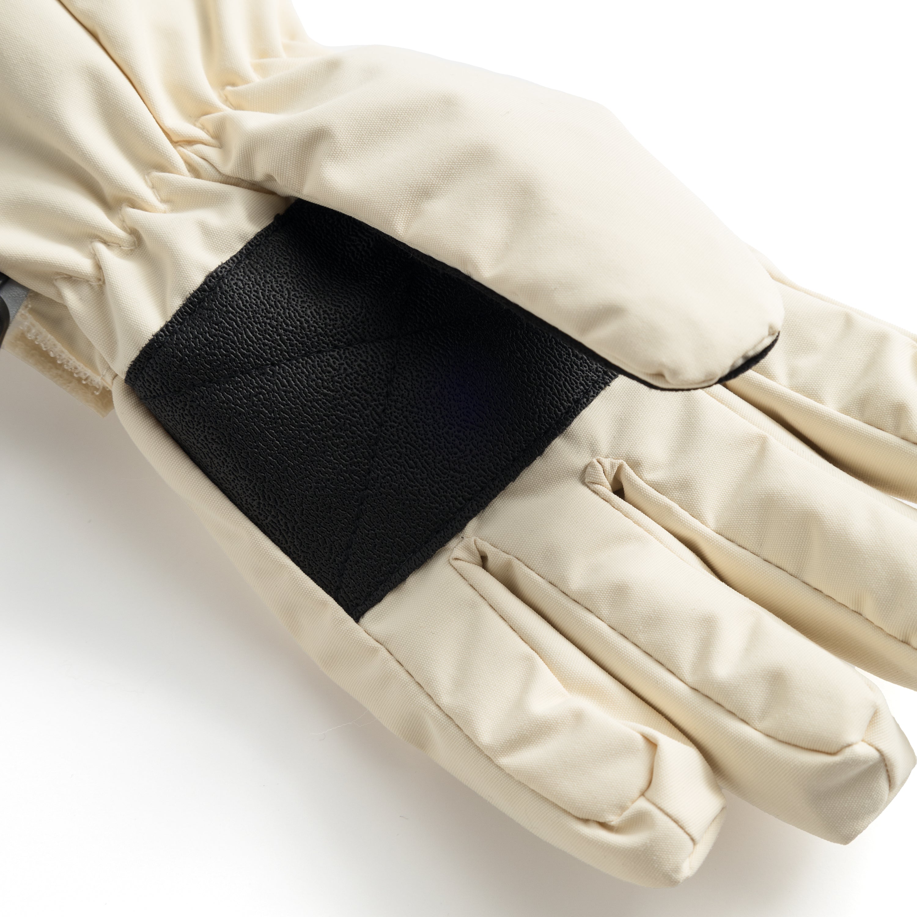 MATCELIO gloves in cream photographed in close-up to show the black elasticated wrist cuff positioned inside the extended cream cuff, demonstrating the dual-layer construction that seals out cold air and snow during winter wear.
