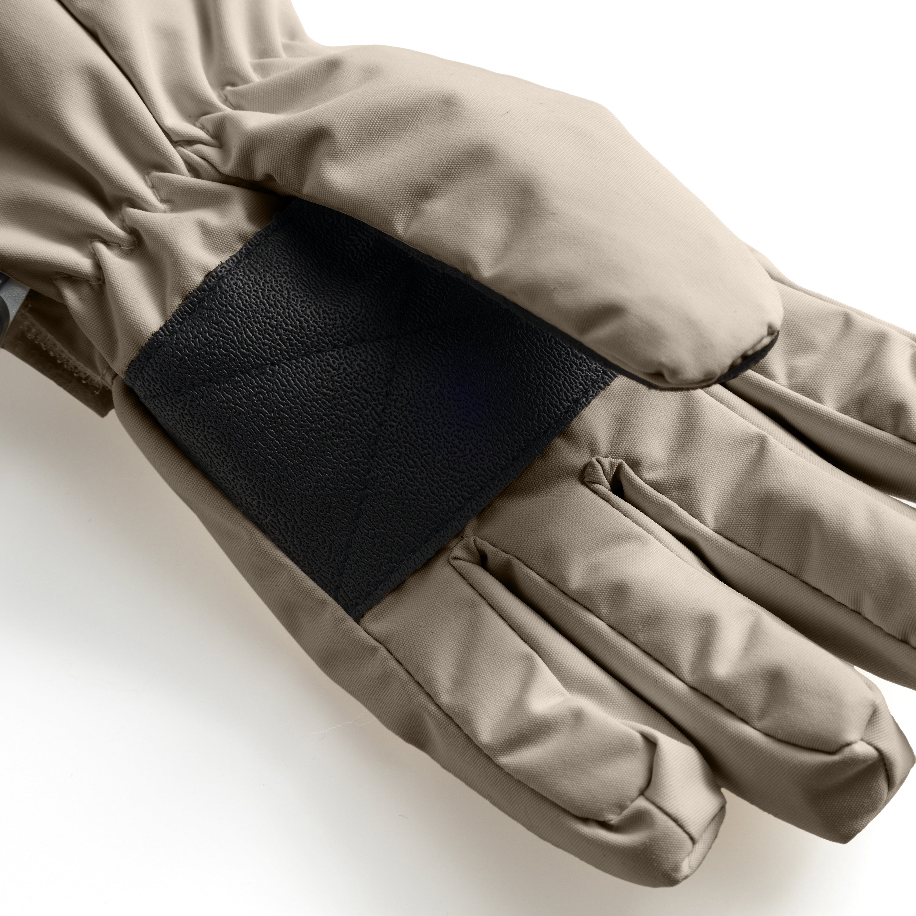 MATCELIO gloves in warm taupe photographed in close-up to show the black elasticated wrist cuff positioned inside the extended taupe cuff, demonstrating the dual-layer construction that seals out cold air and snow during winter wear.