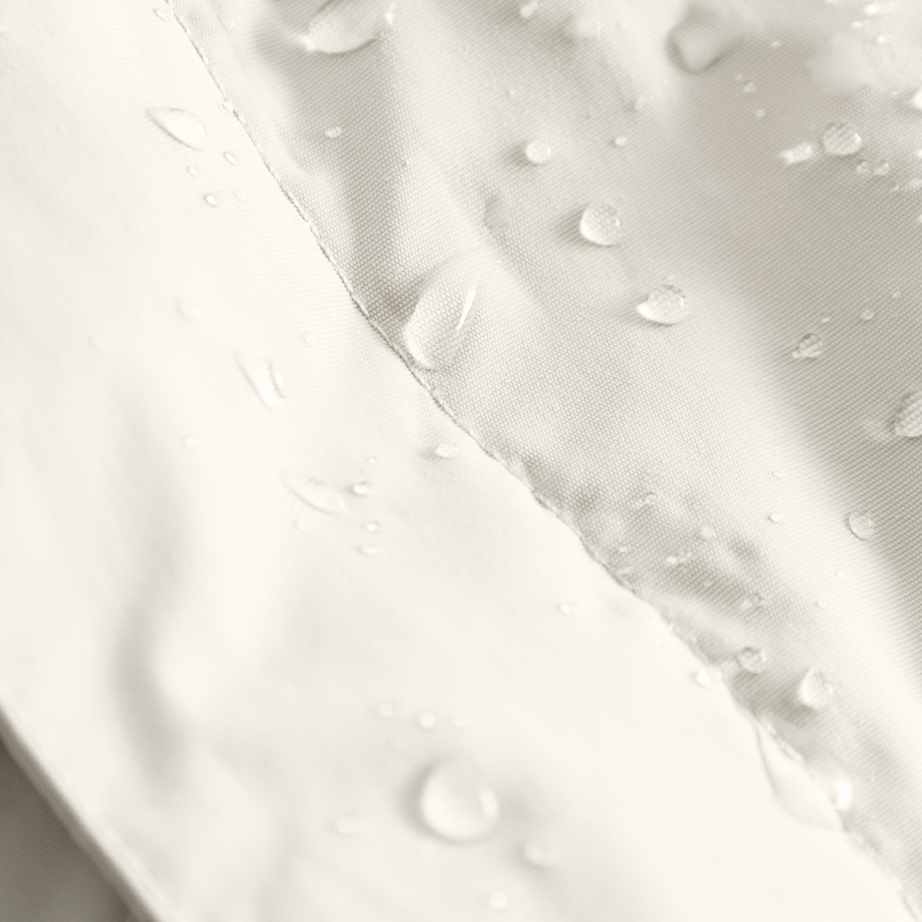 MATBABYWEN anorak in cream showing water droplets beading on the fluorine-free Bionic Finish Eco treated surface, demonstrating the water-repellent properties of the recycled polyamide shell fabric.