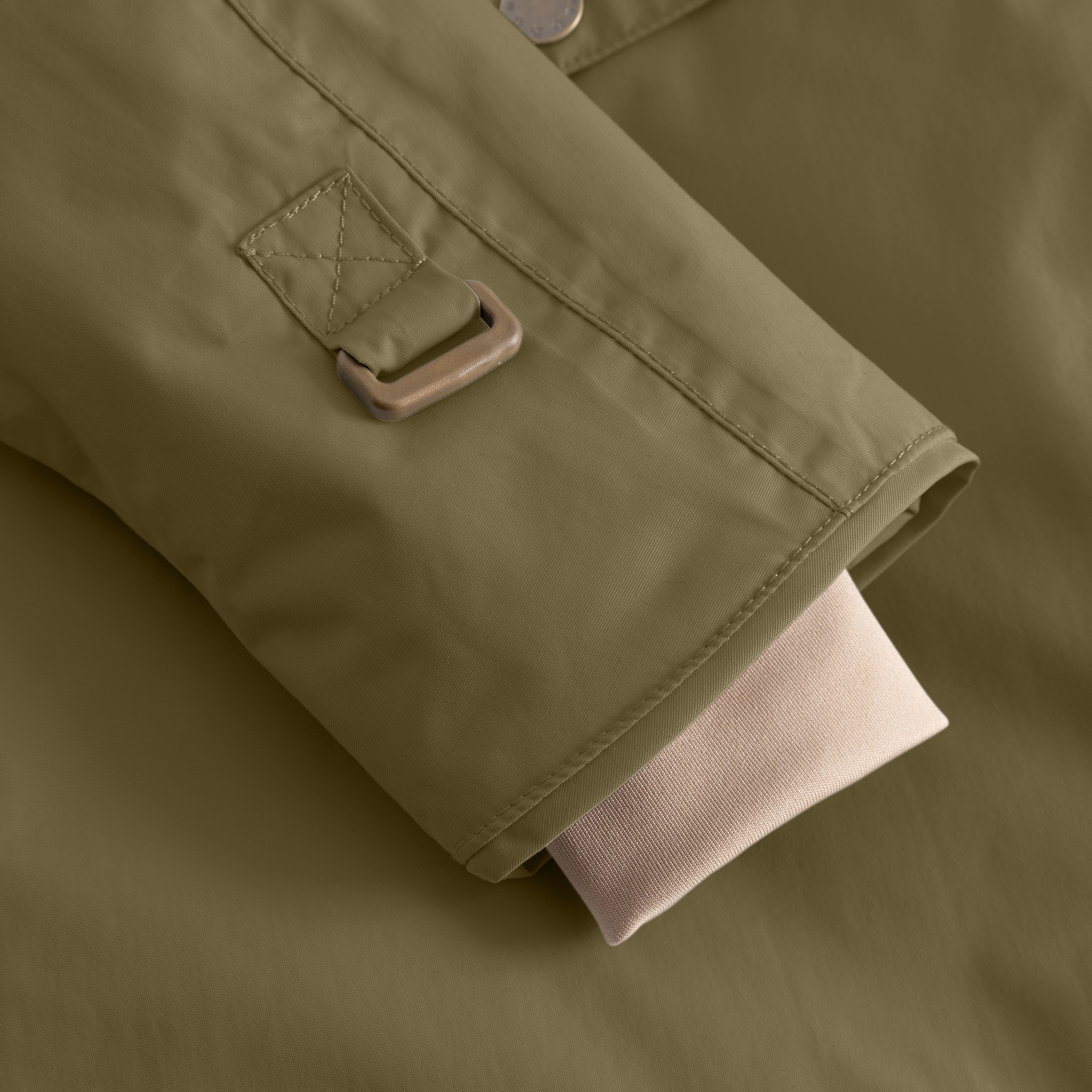 Detail of the MATWANG fleece-lined winter jacket's right sleeve cuff showing the bronze-toned metal buckle fastening on the adjustable snow cuff, flat-felled seam construction, and beige fleece lining extending from the wrist opening.