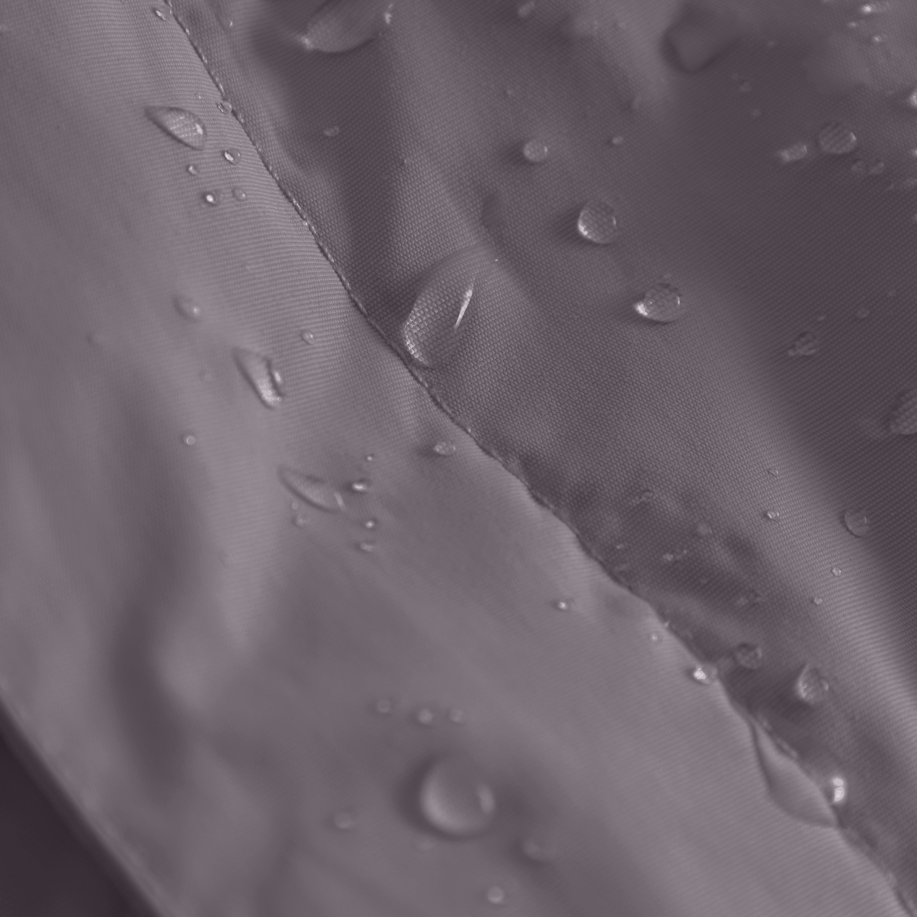 Close-up of the MATWANG fleece-lined winter jacket's waterproof recycled nylon shell with water droplets beading across the surface, showing the fully taped seam construction running diagonally through the frame and demonstrating the fluorine-free Bionic Finish Eco treatment's water-repellent performance.