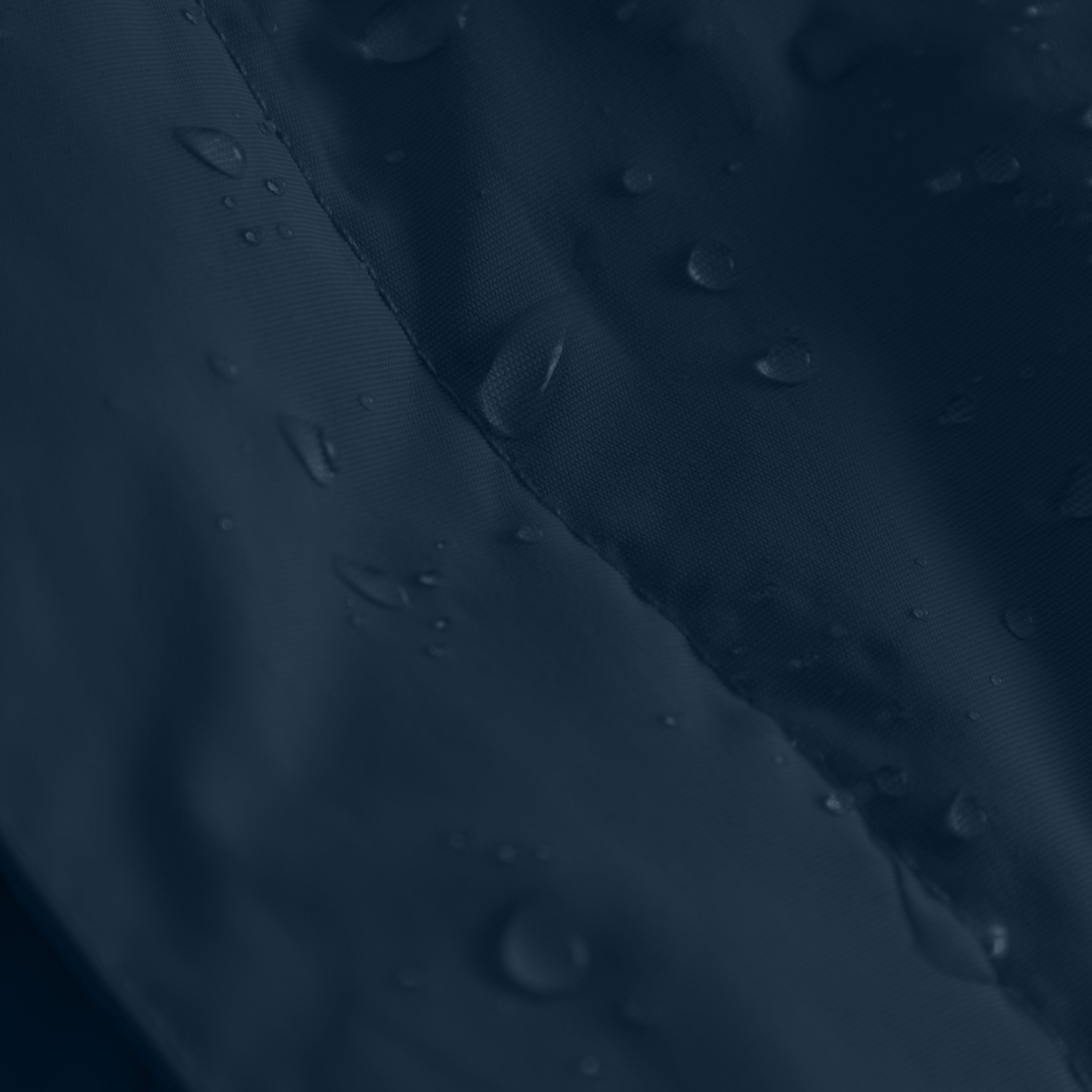 Close-up of water-repellent recycled nylon fabric with water droplets beading on the surface, showing the textured weave and seam construction of a waterproof children's winter jacket.