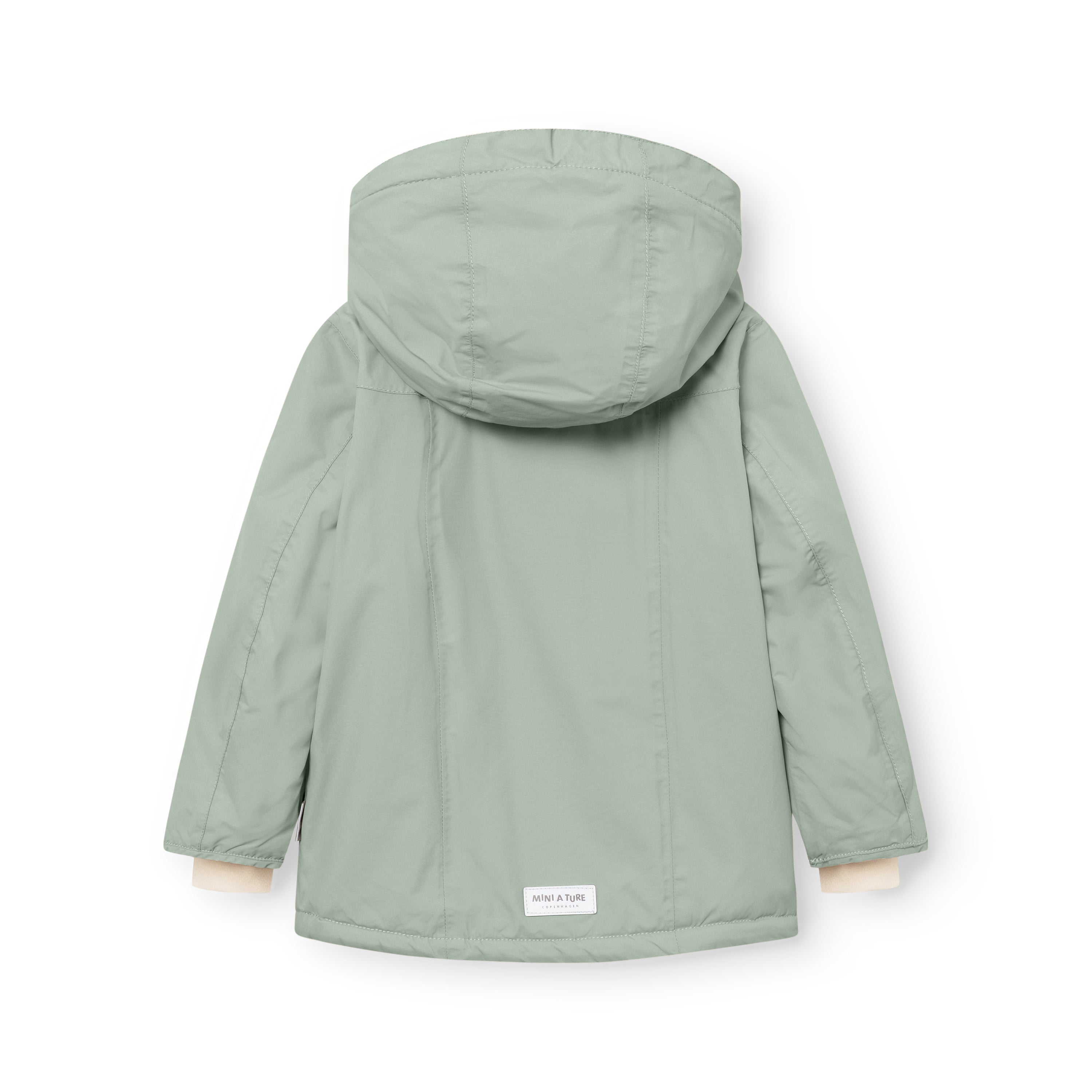 MATVESTYN winter jacket in sage green viewed from behind, showing the detachable hood with internal wind trap, shaped sleeves for improved movement, and a white MINI A TURE label at the lower hem.