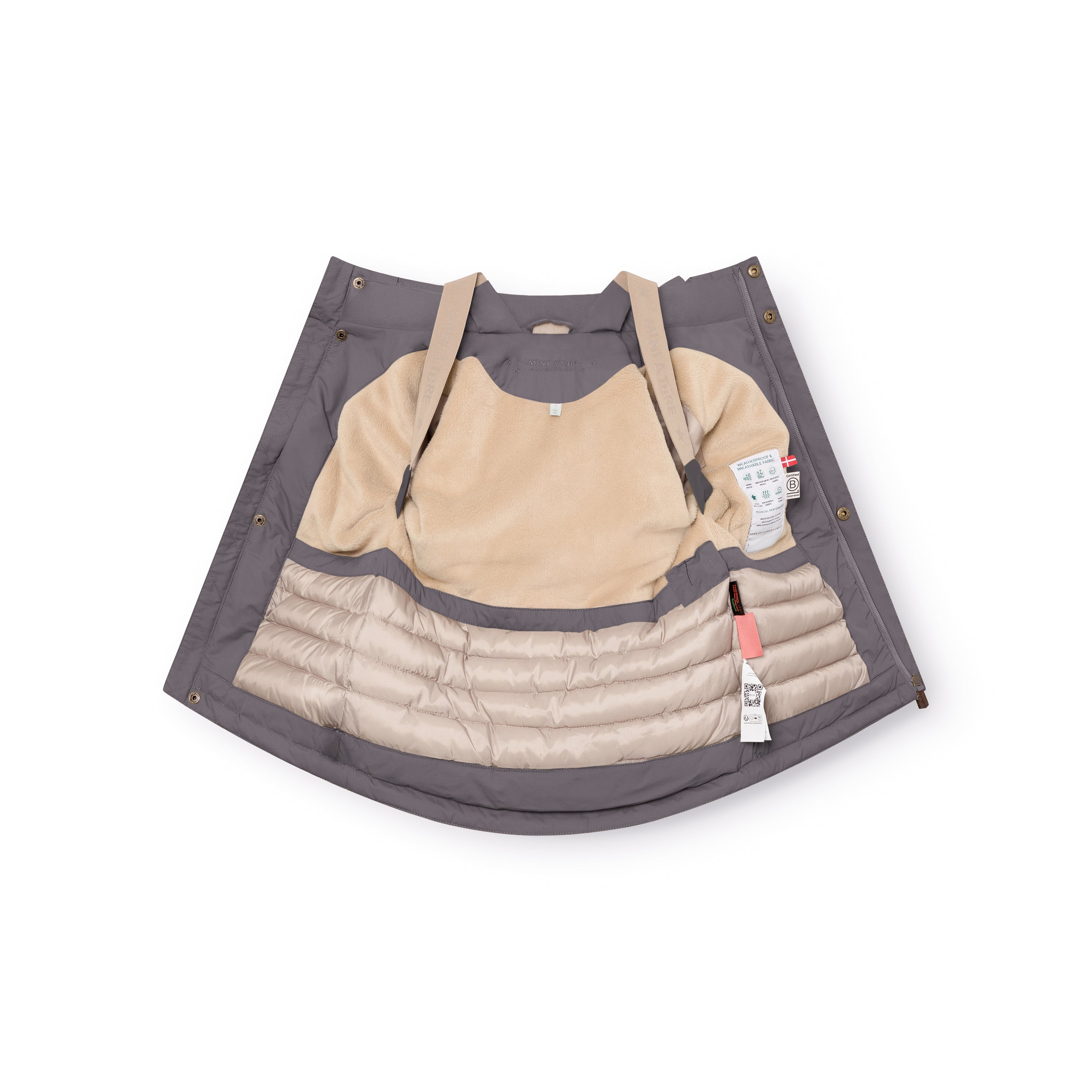 Charcoal grey MATKASTORIO fleece lined winter jacket laid open to reveal the beige fleece-lined upper interior, beige adjustable suspenders, cream Sorona Aura padded lower section with horizontal quilting, snap-button placket along the front edges, and product care labels visible on the inner right side.