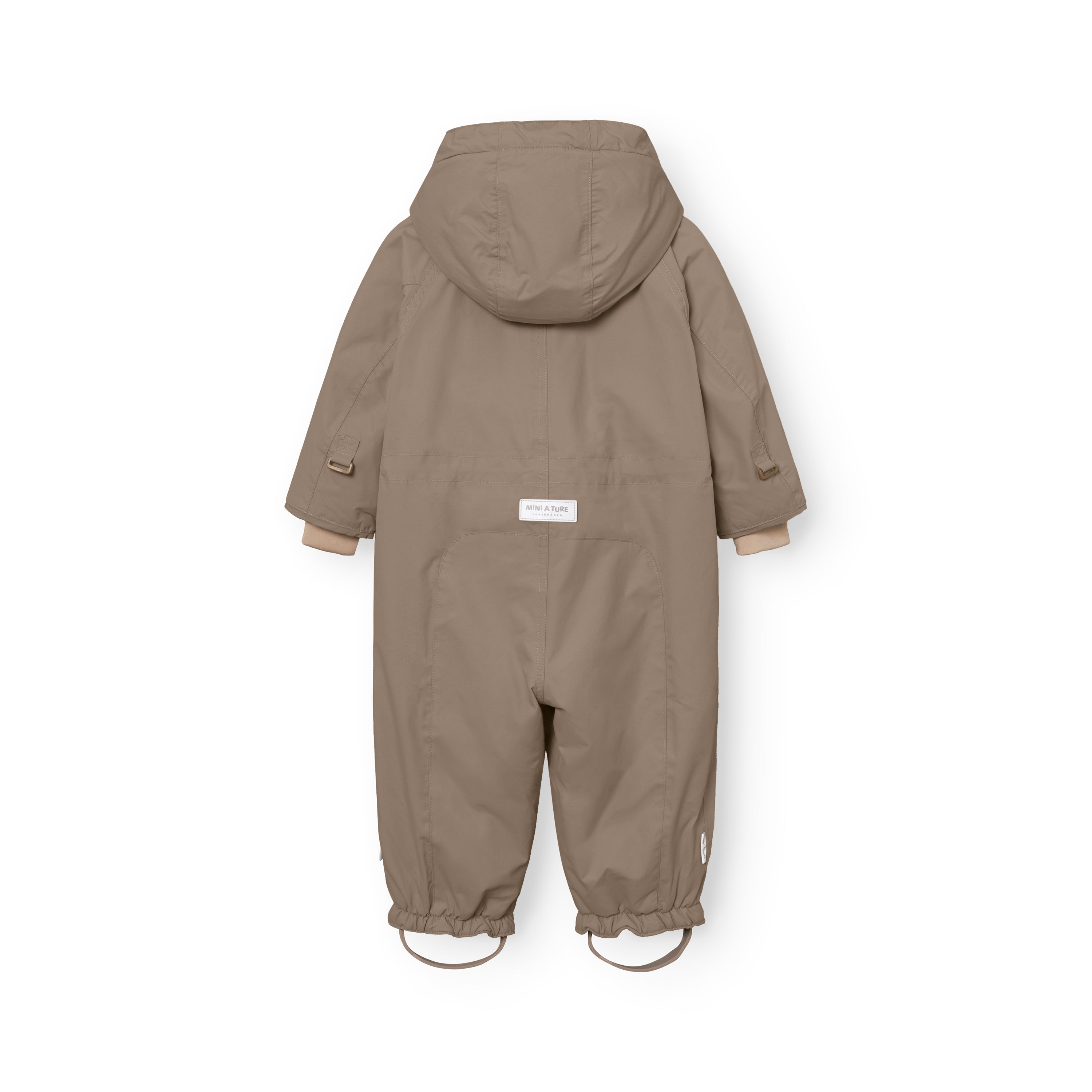 MATWISTI fleece lined snowsuit in warm beige laid flat showing the rear view with detachable hood, white MINI A TURE label at the lower back, beige ribbed cuffs and elasticated leg openings with adjustable foot straps featuring metal D-rings.
